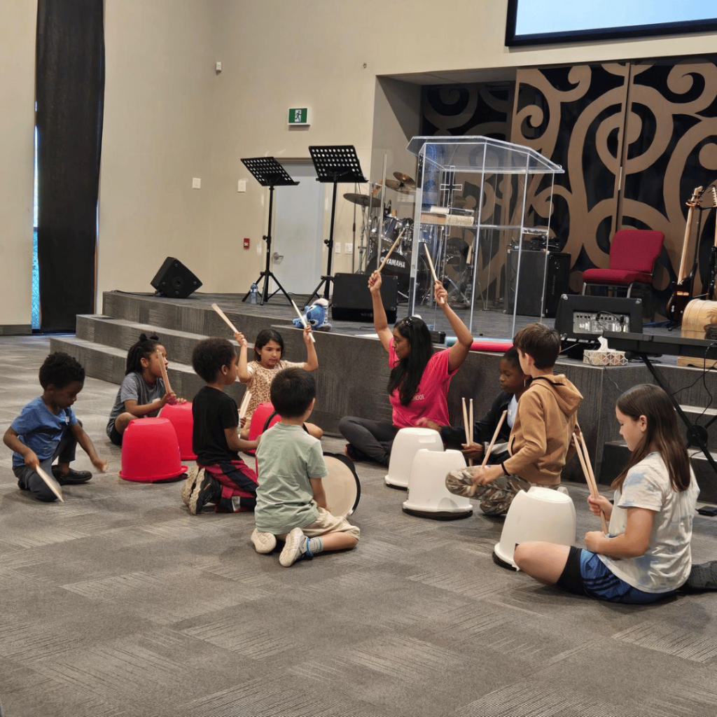 Kids learning rhythm and coordination through a bucket drumming class at Nova Music School’s Music, Martial Arts & Mindset event.